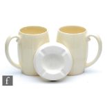 Two Keith Murray for Wedgwood tankards in cream with vertical ribbed bands, printed signature