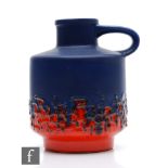 A mid 20th Century German flower jug decorated in a matt royal blue to gloss red fat lava type glaze