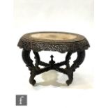 A 19th Century Anglo Indian carved Padouk wood oval centre table, the top decorated with exotic