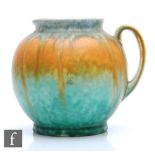 A Ruskin Pottery flower jug of ovoid form with loop handle and slightly pronounced spout glazed in