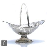 A hallmarked silver oval pedestal swing basket with part pierced decoration, weight 17oz, length