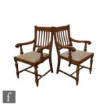 A pair of 1930s oak elbow chairs, slat backs, overstuffed tapestry seats, on turned legs to the