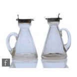 Two hallmarked silver and clear glass toddy jugs of typical form, each with silver collar and hinged