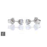 A pair of 9ct white gold diamond solitaire stud earrings, brilliant cut stones each approximately