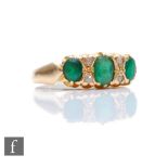 A 15ct emerald and diamond seven stone boat shaped ring, three emeralds spaced by diamond, weight