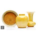 Three pieces of Ruskin Pottery comprising a yellow lustre ginger jar base, damaged, a small yellow