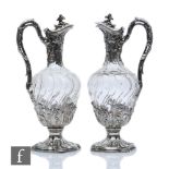A pair of late 19th Century French silver claret jugs, cushioned square bases with foliate details