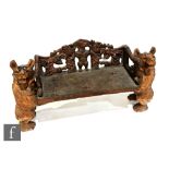 A contemporary Black Forest carved wooden bench seat, the reticulated back panel carved with a