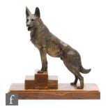 An Art Deco sculpture after L Carvin, of a German shepherd dog standing at the ready on a stepped