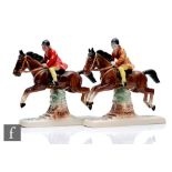 Two Hertwig Katzhutte models of female horse riders dressed in red and yellow jumping a fence,