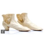 A pair of early to mid 19th Century white kid leather ladies boots with a lace panel to the side.