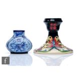 Two boxed pieces of Moorcroft Pottery comprising a vase decorated in the blue on blue