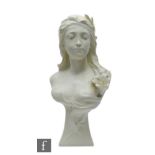 A composite resin bust of an Art Nouveau maiden with flower, cream colour, on wedge shaped base,
