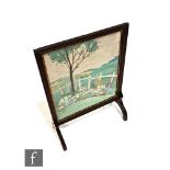 A 1930s oak framed fire screen, with embroidered panel depicting a garden scene with hills to the