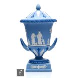 A Wedgwood two colour Jasperware twin handled campana urn and cover decorated in relief with