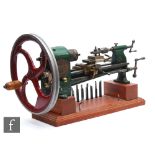 A large Damaco 5 watch makers lathe, green painted, with tools, on a stepped mahogany base, length
