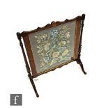 A 1920s walnut framed fire screen, embroidered with a parrot amidst foliage on shaped end