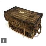 A World War Two era wicker trunk with twin rope handles and metal securing rod, the canvas cover