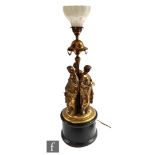 An early 20th Century brass lamp in the Grand Tour style depicting the three graces below a Vaseline