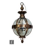 A large late 20th Century brass framed and glazed light fitting, modelled as a sphere with six