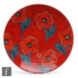 A large later boxed 20th Century Poole Pottery charger decorated with stylised poppies against a red