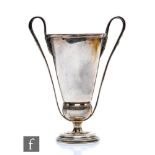 A George V hallmarked silver pedestal trophy cup in the Art Nouveau style with sinuous handles