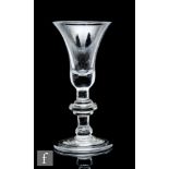 An 18th Century drinking glass circa 1730, the flared bell form bowl above a balustroid stem with