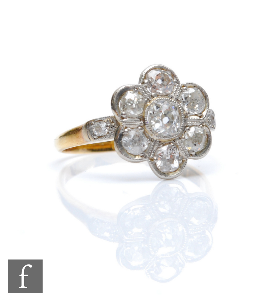 An early 20th Century 18ct diamond daisy cluster ring, seven collar set old cut stones, total weight