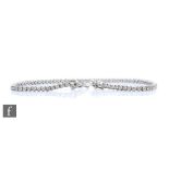 An 18ct white gold diamond tennis bracelet comprising claw set brilliant cut stones, total weight