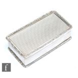 A hallmarked silver rectangular snuff box with engine turned decoration within raised foliate border