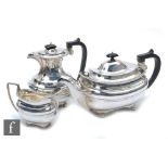 A hallmarked three piece boat shaped tea set comprising tea and water pot and a cream jug, each