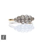 An early 20th Century 18ct diamond elongated oval cluster ring, ten millgrain set old cut stones