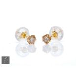 A pair of 18ct diamond solitaire stud earrings, each approximately .020ct, to a six claw setting,