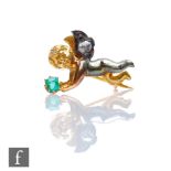 A 19th Century two coloured small gold pin modelled as a standing cherub holding an emerald and with