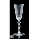 An 18th Century ale glass, circa 1780, the elongated round funnel bowl with basal petal moulded