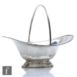 A hallmarked silver oval swing basket with pierced decoration to foot and borders, weight 13.5oz,