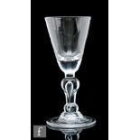 An 18th Century baluster drinking glass circa 1700 to 1710, the round funnel bowl above an