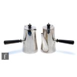 A hallmarked silver pair of cafe au lait pots, each of plain cylindrical from and terminating in
