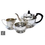 A hallmarked silver three piece tea set each with a circular stepped foot below plain bodies, pot