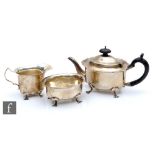 A hallmarked silver three piece bachelor's boat shaped tea set, each raised on four pad feet,