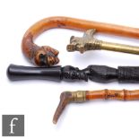 A 20th Century carved African walking stick, a brass handled stick, a plain walking stick with
