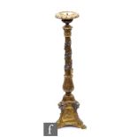 A late 19th to early 20th Century brass pricket altar candlestick embossed with vines over angelic