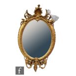 A late 19th to early 20th Century girandole wall mirror of oval form within a moulded gilt and gesso