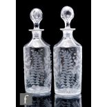 A pair of late 19th to early 20th Century clear crystal decanters, of cylinder form with tapered