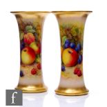 A mirrored pair of Royal Worcester Fallen Fruits lily vases, panel decorated by Lockyer with hand