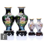 A collection of Chinese cloisonne vases, to include a black pair detailed with gilt ruyi scroll