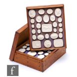 A set of replica Grand Tour cameos contained in four wooden trays, 28cm x 23cm.