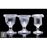 A near pair of early 19th Century clear crystal egg cups, of ovoid form with lipped rim above a