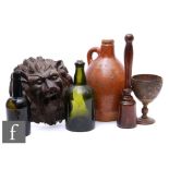 An early 19th Century small salt glazed flagon, two bottles, a carved coconut cup on turned stand, a