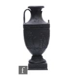 A late 19th Century Wedgwood black basalt neoclassical twin handled vase affixed to a square